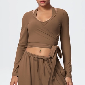 Detail of mocha brown yoga set featuring cross wrap tie-up top and high waist leggings