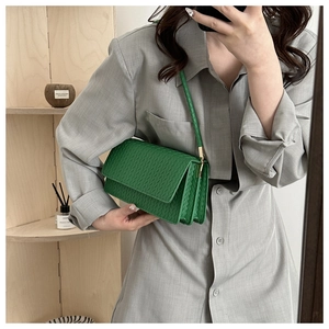 Close-up of green woven texture and double compartment design on a shoulder bag