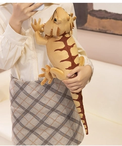 Detail of soft plush bearded dragon toy shown in hands to demonstrate realistic scale