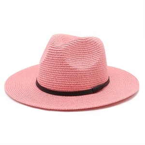 Detail of pink straw fedora hat featuring a thin black leather band for summer beach style