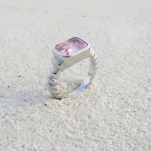 Detailed macro view of silver twisted ring band with rectangular pink gemstone