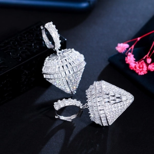 Dettaglio macro di orecchini a cuore in argento con zirconi micro-pave su sfondo nero