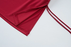 Detailed close-up of the red drawstring design and stitched hem on a short dress