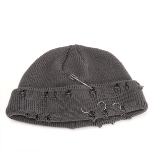 Macro detail of dark grey beanie featuring punk style distressed holes and metal rings