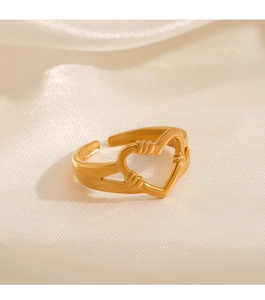 Detailed view of the gold heart-shaped ring on a silk background with soft lighting