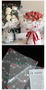 Detail of Christmas snowflake cellophane wrap with red, green and white pom-poms