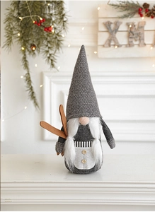 Détail de figurine de gnome de Noël avec bonnet en tricot et skis en bois sur cheminée
