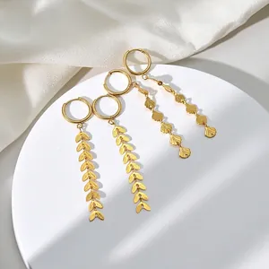 Golden fringe wheat ear and shell pattern tassel earrings on a silk background