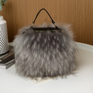 Detail of grey faux fur handbag with dark brown handles and golden zipper on white table