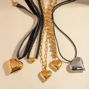 Classic gold heart pendant necklaces set on beige background in various chain styles