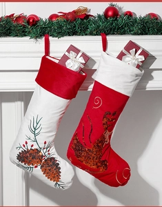 Detailansicht von Plüsch-Weihnachtssocken mit Rentier- und Zapfenmotiven am Kaminsims