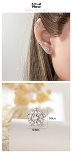 Macro detail of silver snowflake cartilage studs and earrings set measuring 0.9cm