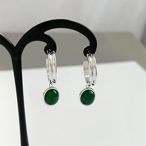 Detail of silver hoop earrings featuring hanging round green aventurine stones