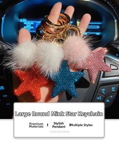 Sparkling crystal star keychain with mink fur pompom held in a car interior setting