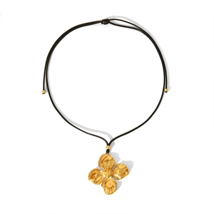 Detailed close-up of a 18K gold floral pendant necklace with adjustable black cord string