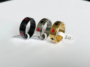 Detail of spinning spinner ring showing black, gold and silver poker cards pattern suits