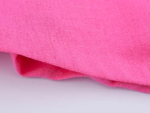 Détail macro du tissu en lin rose vif avec couture soignée et texture à armure toile