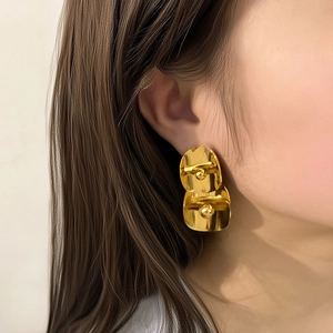 Boucles d'oreilles géométriques dorées à double couche avec une finition métallique