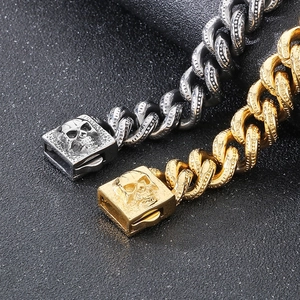 Punk rock skull cuban link bracelet in gold and silver finish on textured dark background