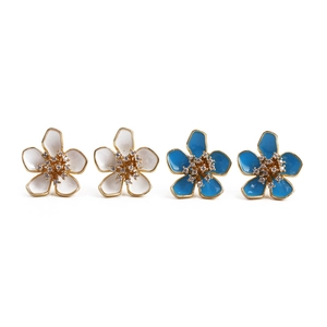 Dettaglio di orecchini a fiore con petali in smalto bianco e blu e centri in cristallo