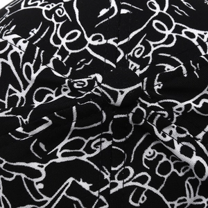 Top macro view of cotton baseball cap showing black fabric with white graffiti print