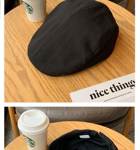 Detail view of the black retro newsboy cap showing twill fabric texture and inner labels
