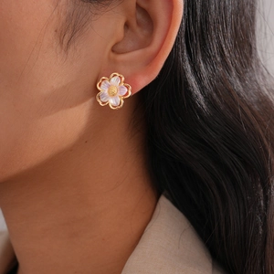 Detail of flower stud earring with purple mother of pearl petals and gold trim