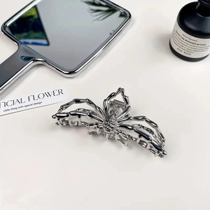 Détail macro d'une pince à cheveux araignée en métal argenté au design punk moderne