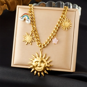 Detail of gold sun face and rainbow cloud charms on a stainless steel chain necklace