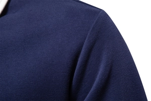 Macro shot showing the high-quality knit texture and shoulder seam of the navy blue polo