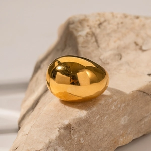 Dettaglio di un anello bombato in acciaio inossidabile dorato 18K su una base di pietra naturale
