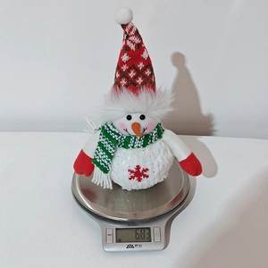 Detailed view of 68.3g plush Christmas snowman doll being weighed on a scale