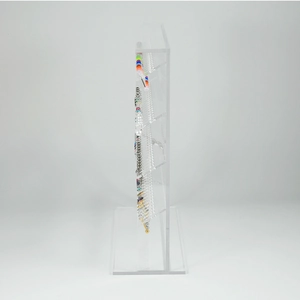 Detailed side view of clear acrylic jewelry display stand with multiple piercing studs