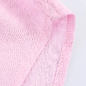Detailed macro view of pink linen cotton fabric showing fine stitching and woven texture