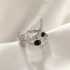 Detail of irregular silver branch ring featuring dual black zircons on white silk fabric