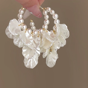 Détail de pétales de fleurs en résine blanche et perles synthétiques sur boucles d'oreilles