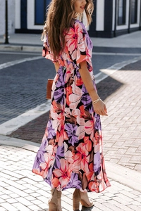 Detail view of floral maxi dress with vibrant pink and purple patterns and side slit