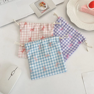 Detailed close-up of checkered drawstring storage bags with cute bow prints