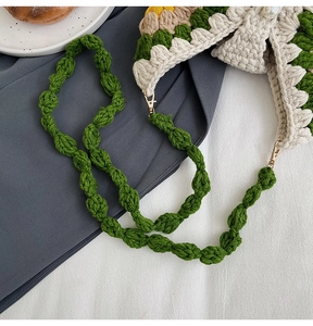 Detail of crochet sunflower bag with green woven strap and gold lobster clasp