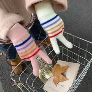 Rainbow striped touchscreen knitted gloves for women shown in a cozy outdoor autumn setting