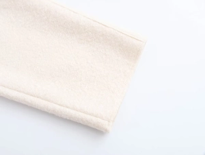 Close-up of beige wool coat cuffs showing high-quality texture and precise stitching detail