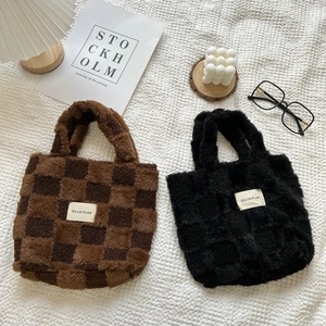 Detail of plush checkerboard tote bags in brown and black with minimalist decor