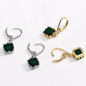 Détail de boucles d'oreilles émeraude carrées en or 18 carats et argent avec zircons