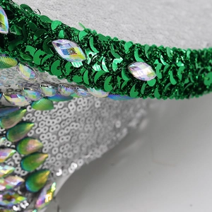 Macro shot of green sequins and iridescent crystal gems on a punk style festival hat