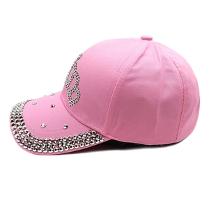 Close-up of pink baseball cap featuring silver rhinestone crown B and studded brim detail