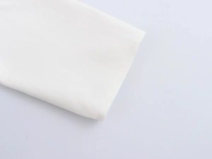 Detailed macro view of white corduroy fabric texture and professional hemmed edge finishing