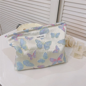 Close-up of butterfly jacquard fabric detail and 'simple wish' label on canvas makeup bag
