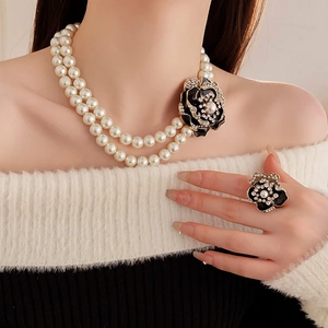Detail of vintage flower necklace and ring set with black petals and pearls