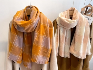Close-up of plaid cashmere-like scarves with fringe details in colorful checkered patterns