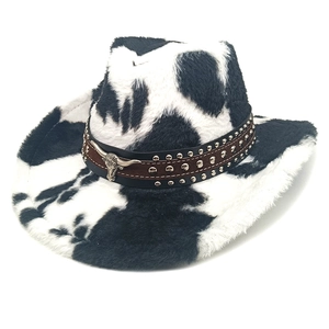 Detail van koeienprint cowboyhoed met leren band met studs en zilveren stierenkop
